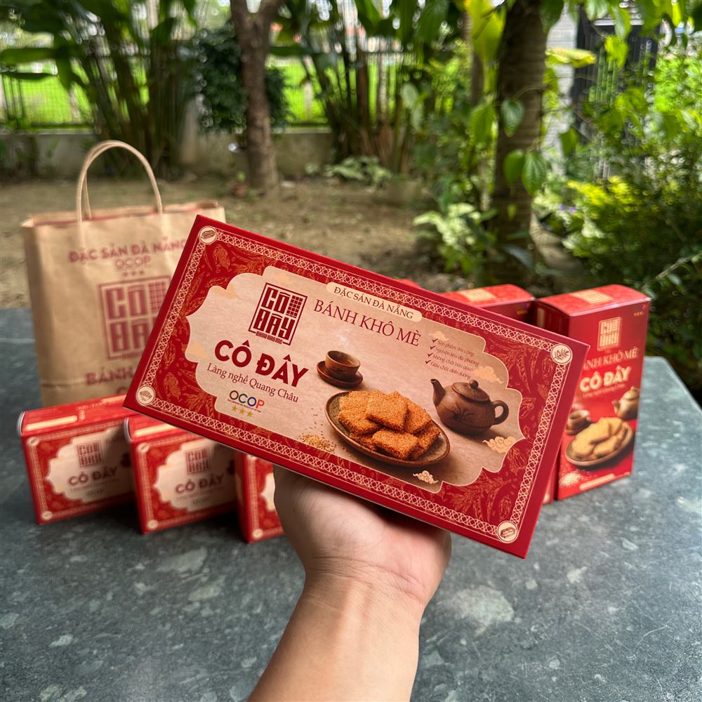 Hộp bánh khô mè Cô Đây cầm trên tay